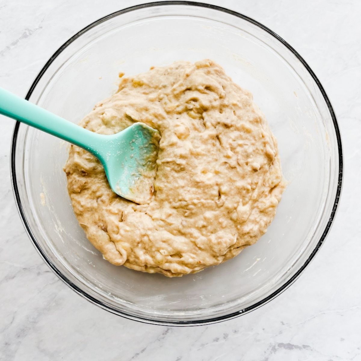 Banana bread muffin batter in a bowl on the counter.