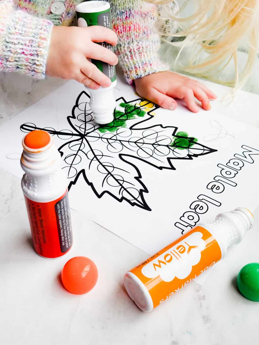 child using dot marker on maple leaf dot marker page.