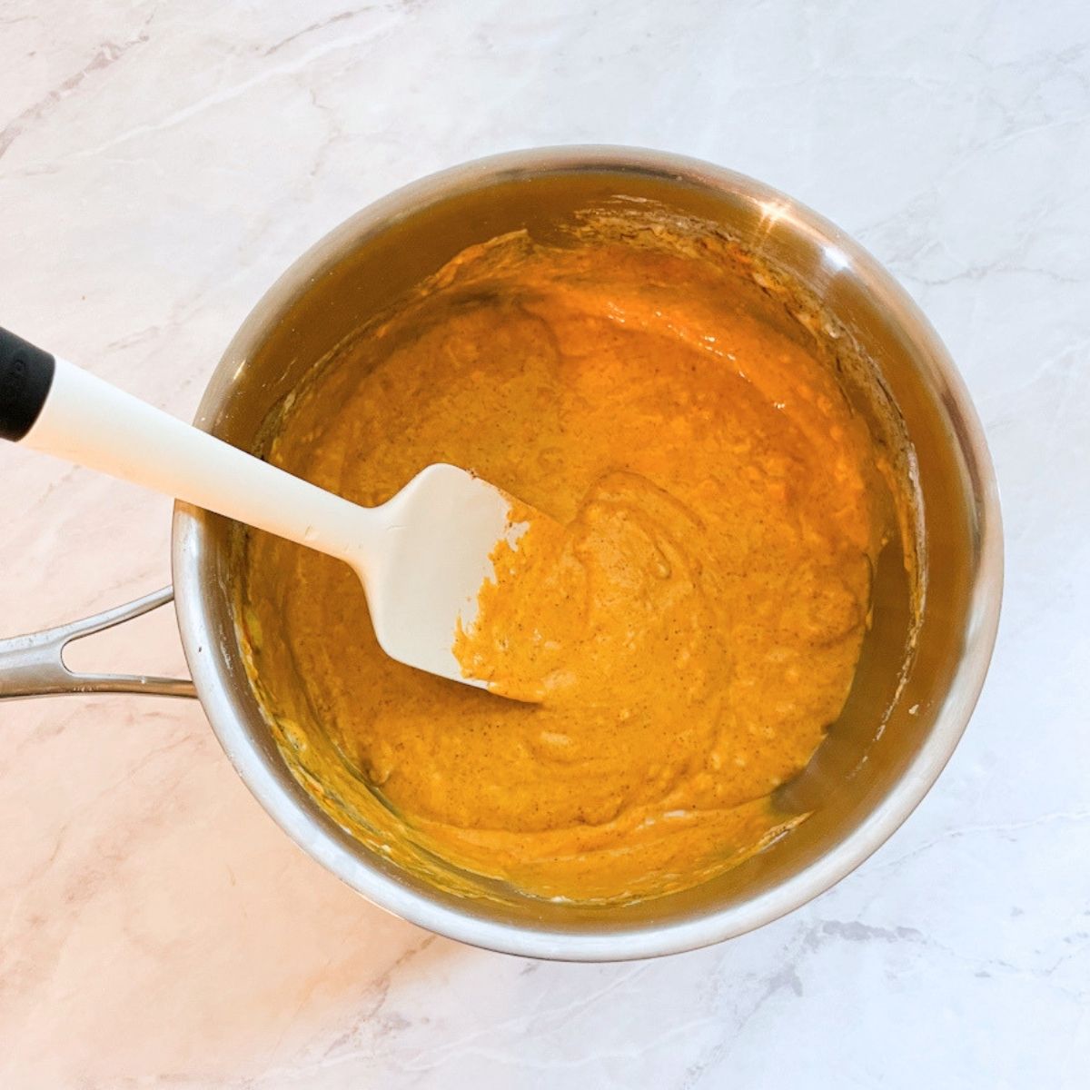 Spatula in a pan with all the ingredients mixed smooth.