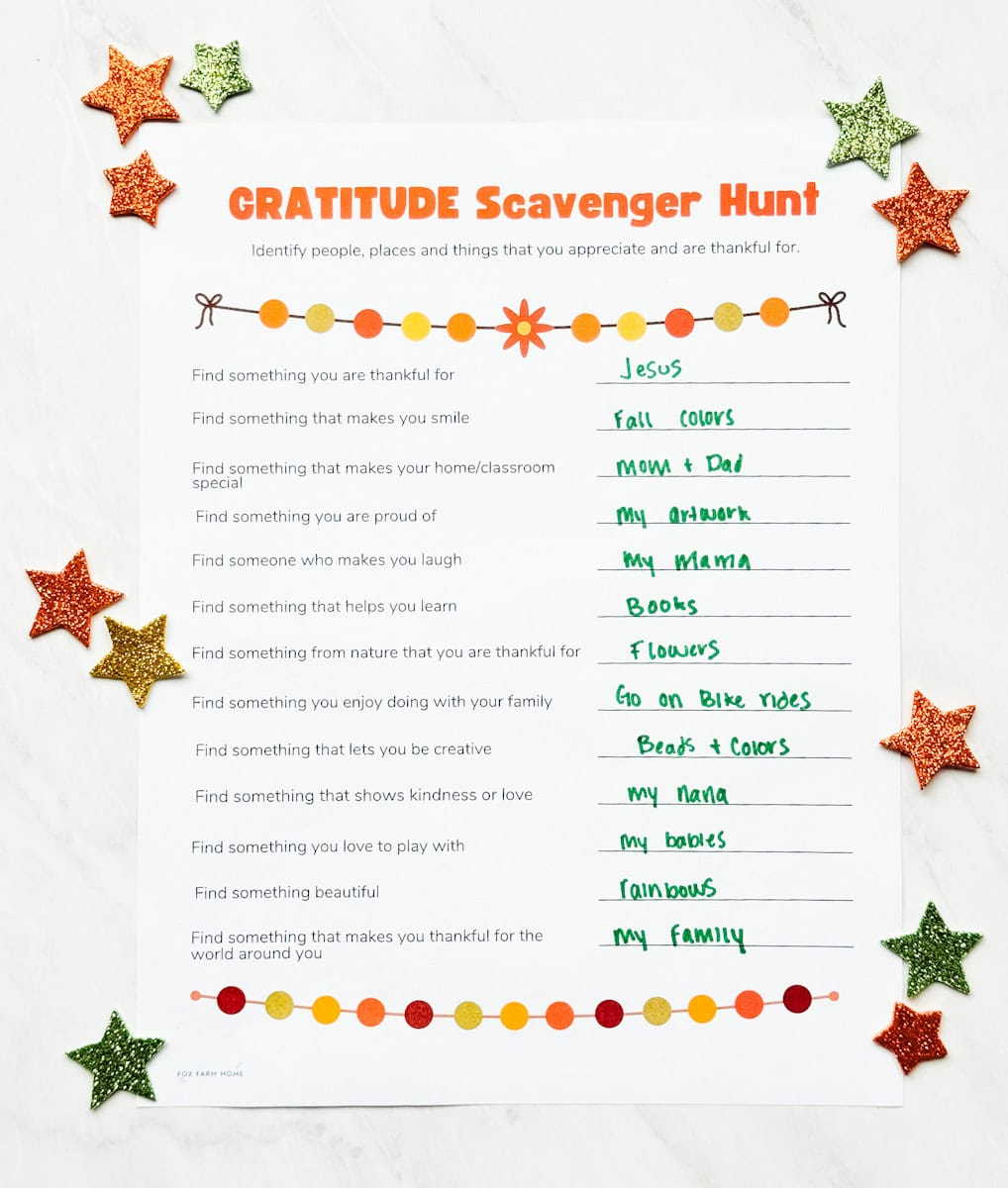 completed gratitude scavenger hunt on table with glitter stars on table around it.