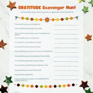 Printed gratitude scavenger hunt on table with glitter stars around it.