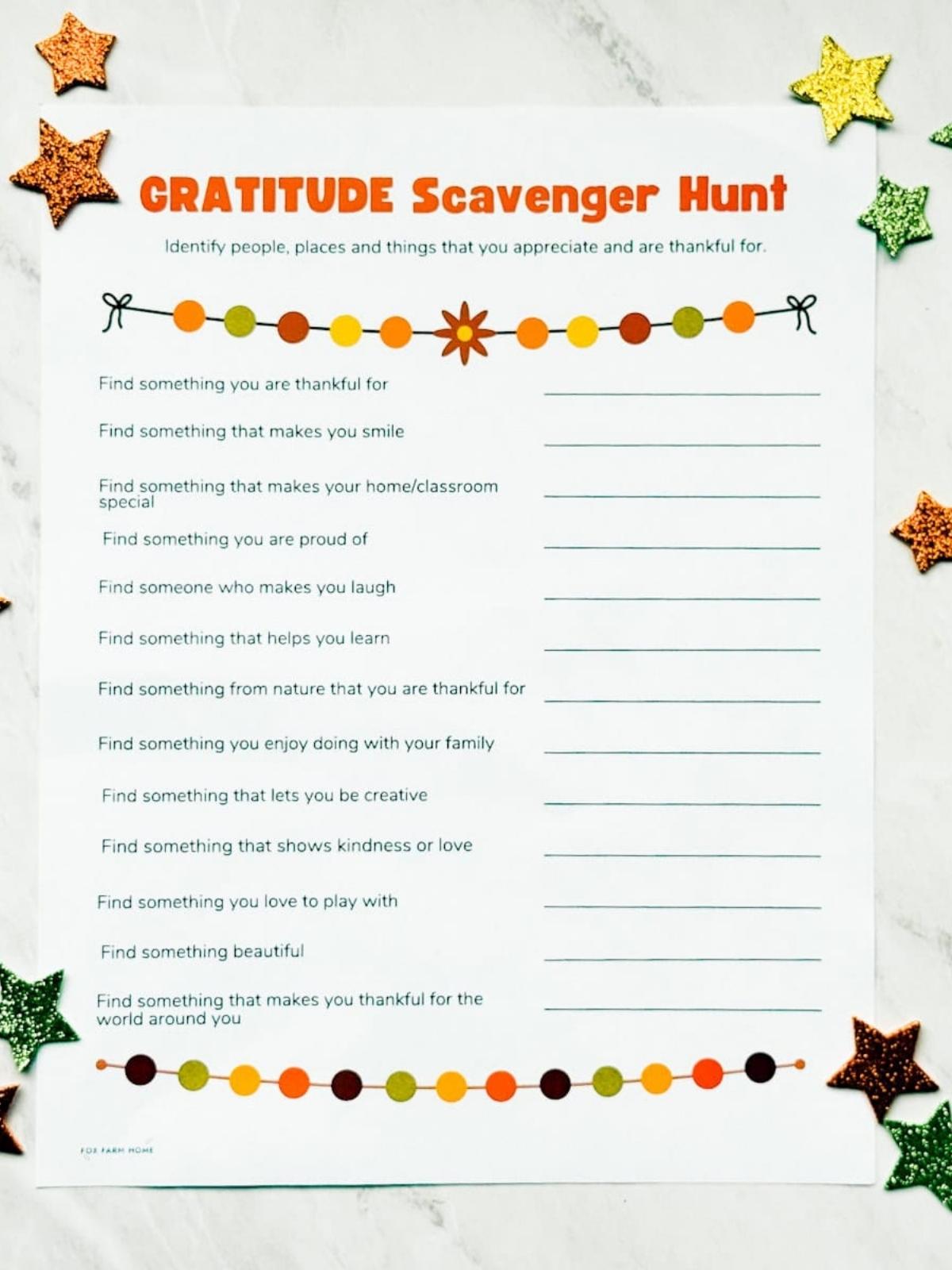 Printed gratitude scavenger hunt on table with glitter stars around it.