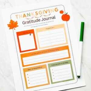 Printable Thanksgiving gratitude journal on table with green marker next to it on table.