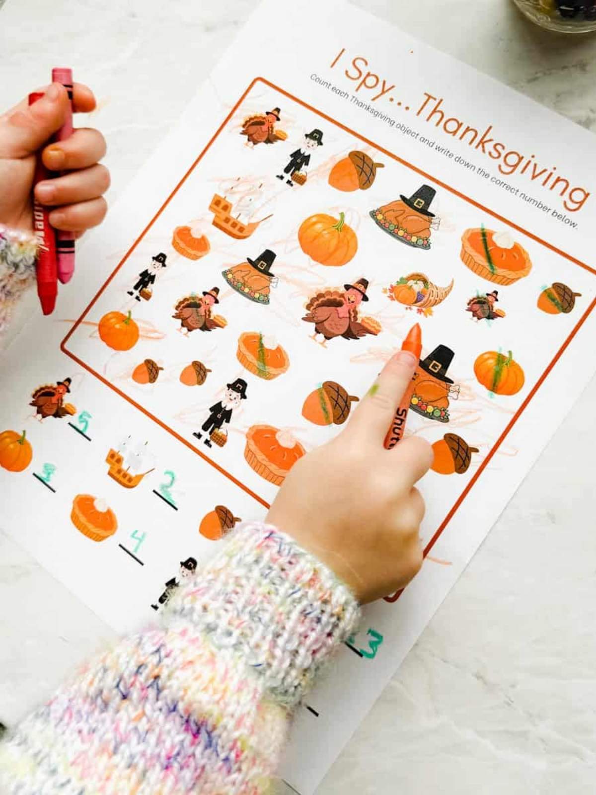 Child with colors in their hand working on the I spy printable.