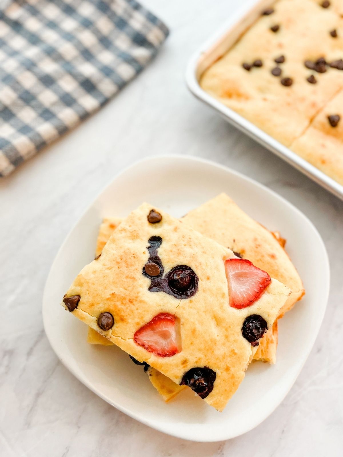 3 ready to serve sheet pan pancakes on a plate. 